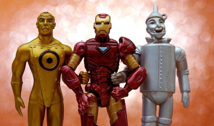Three action figures standing together with linked arms