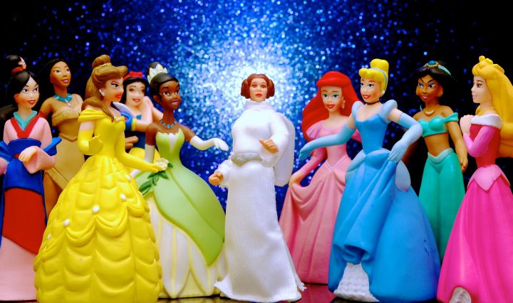 A group of Disney princess action figures standing in a circle and talking to each other.