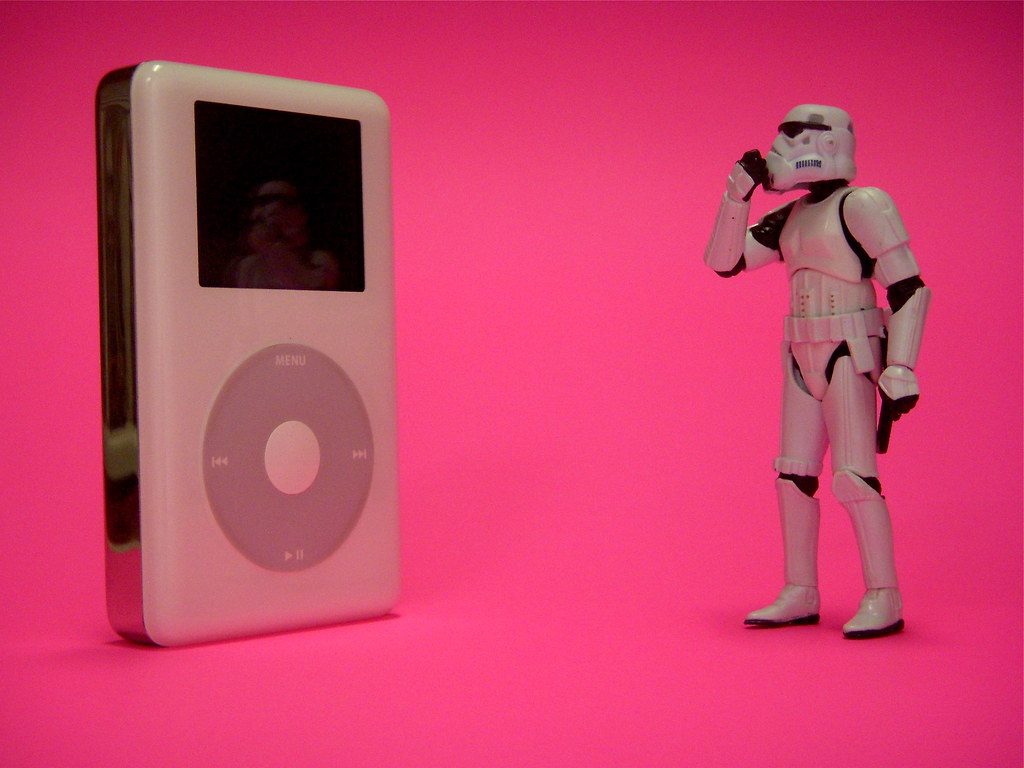 A Storm Trooper from Starwars stands in front of an iPod and looks puzzled