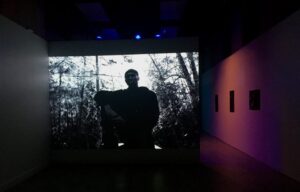 Man silhouetted in a darkened structure backlit by natural light